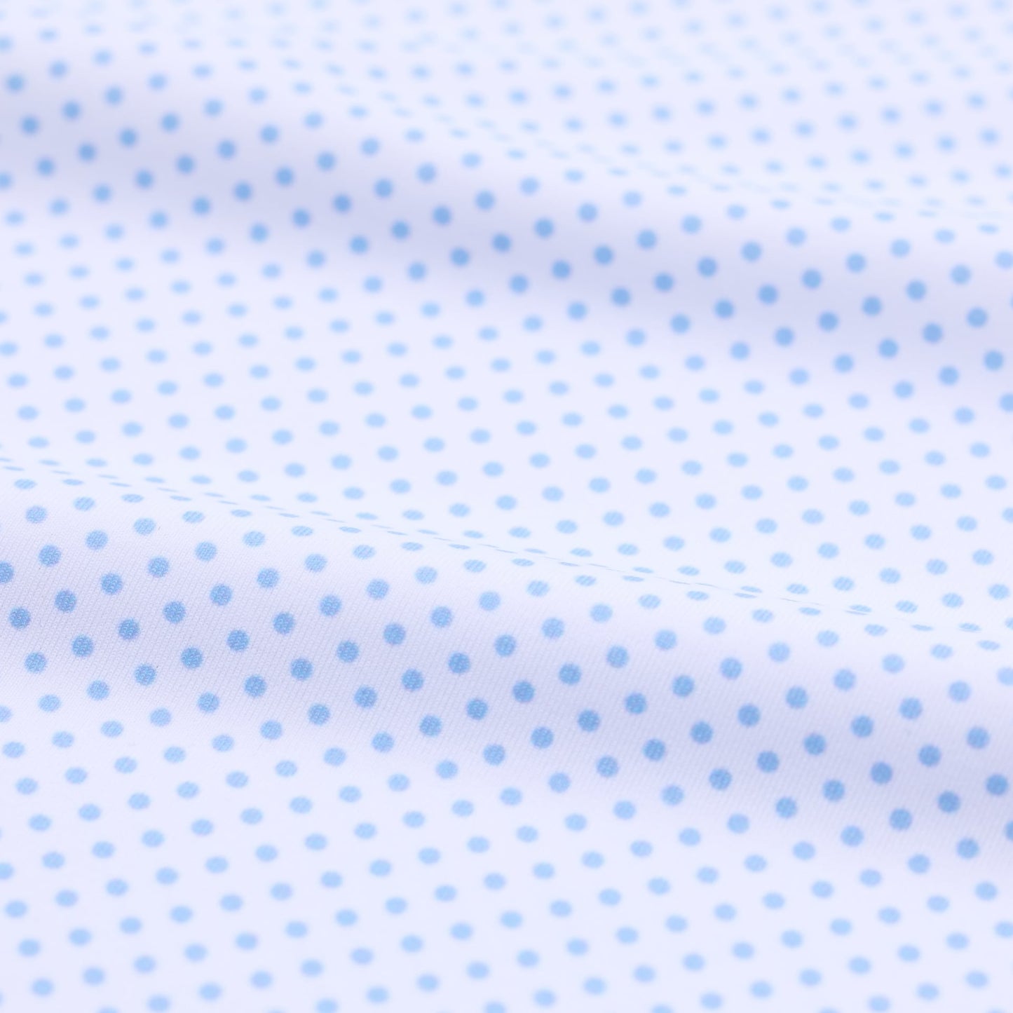 White fabric with small blue polka dots