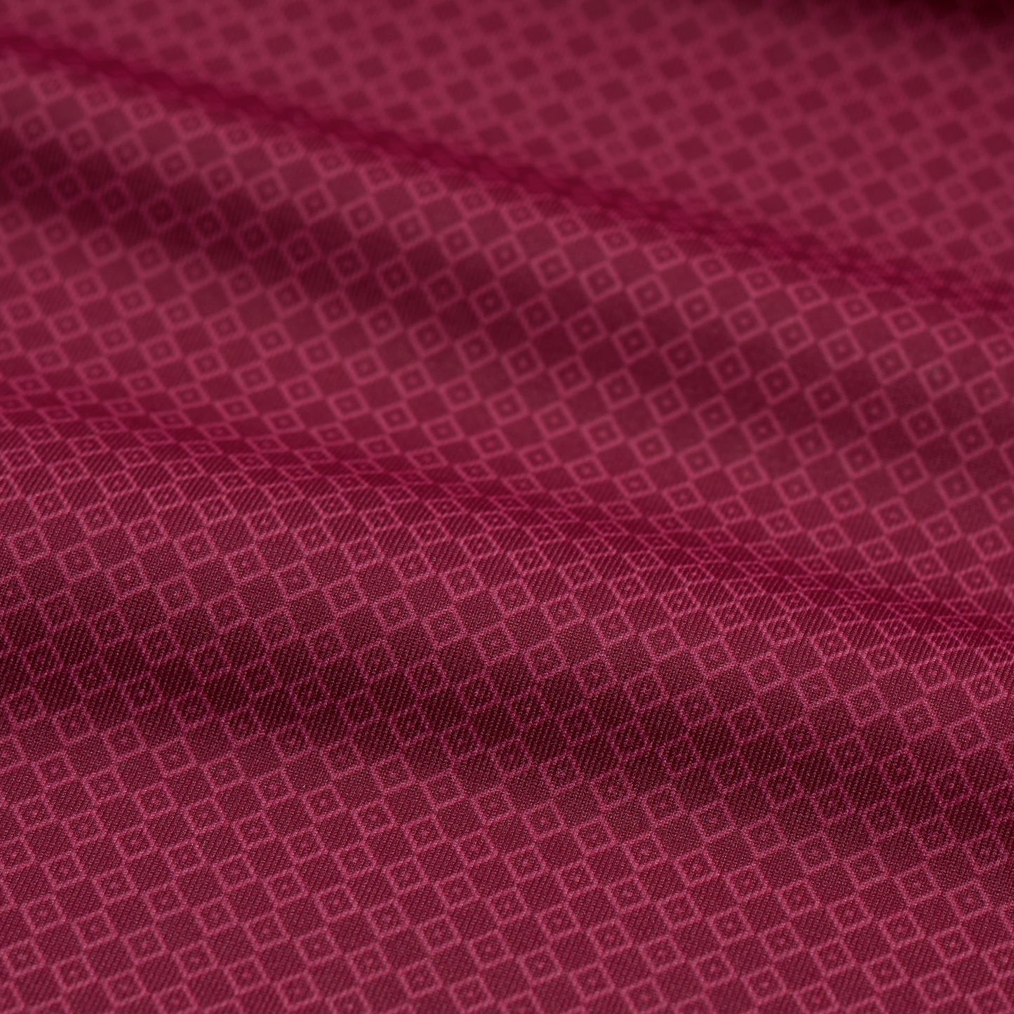Close-up of a red fabric with a subtle geometric pattern