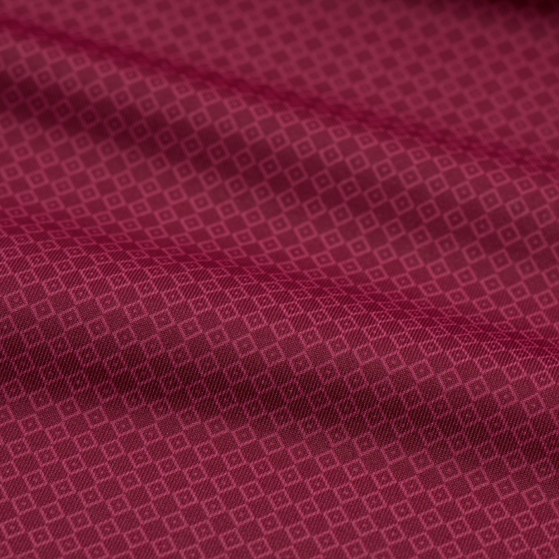 Close-up of a red fabric with a subtle geometric pattern